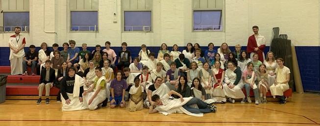 Large group of students at a Junior Classical League conference with teachers. Students wearing togas.