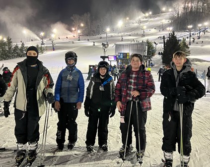 Five kids in skis on a ski slope.